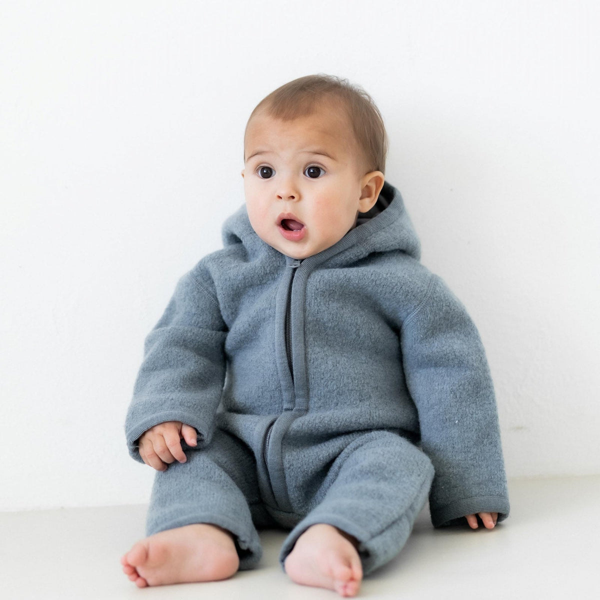 Baby trägt Halfen Walk-Overall in Rauchblau